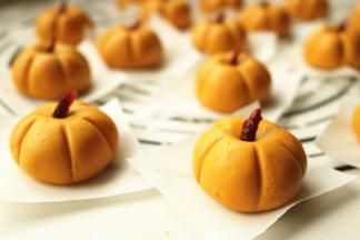 糯米圆子略微用手指按一下，蔓越莓干一切为二，插在凹痕处充当南瓜蒂，用牙签在糯米面团周围按出南瓜的痕迹。全部做好。
