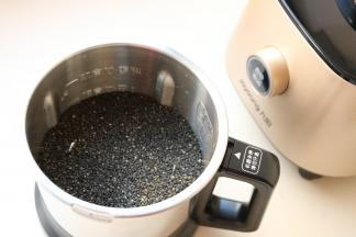 炒熟的黑芝麻放入破壁调理机的不锈钢干磨杯里。