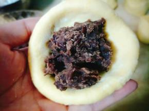 然后放入豆沙，顺时针捏一下，然后整型成圆形的；