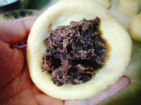 然后放入豆沙，顺时针捏一下，然后整型成圆形的；