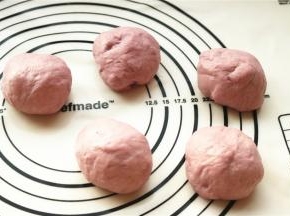 发酵完成，面团饱满可以戳出不回缩的洞，移到揉面垫上排气后分成5份，每份大约70克，静置松弛10分钟。