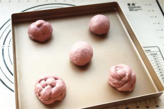 汉堡胚子揉圆，或者搓成两个长条做成绣球状，放在烤盘上，中间要留有距离。