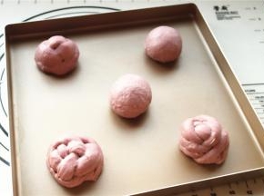 汉堡胚子揉圆，或者搓成两个长条做成绣球状，放在烤盘上，中间要留有距离。