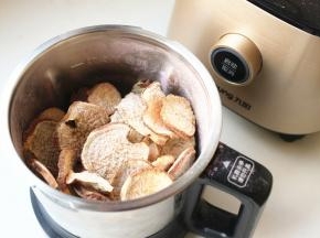 晒干的地瓜干放进破壁调理机的不锈钢干磨杯里。