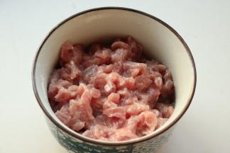 里脊肉切末，加入少许湿淀粉抓匀，加入少许鸡粉和花生油腌制一会。