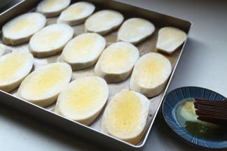 杏鲍菇片排入烤盘，表面也刷上融化的黄油。