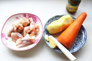 焖饭的时间开始做咖喱鸡。准备好食材，土豆去皮洗净，胡萝卜去皮。