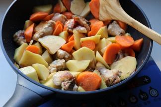 加入胡萝卜块和土豆块炒匀。