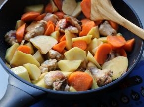 加入胡萝卜块和土豆块炒匀。