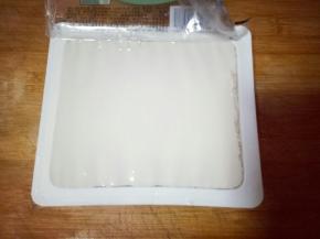 豆腐，打开盒子，倒扣在菜板上，取下盒子，将豆腐切块。