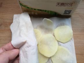 捞出薯片，用纸巾吸干水分。