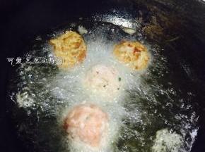8. 另起一个锅，倒入一大碗热油，将搓好的肉丸子油炸一下，下锅不要马上翻动，炸一会再翻过来炸。