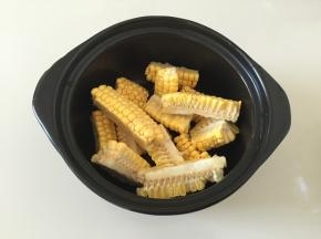 玉米清洗干净切小块放入砂锅内；