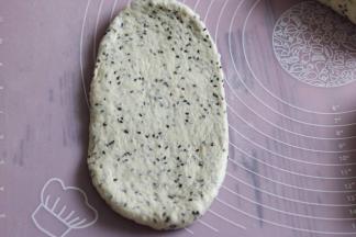 取一个面团，擀成椭圆形，拍去两侧气泡。