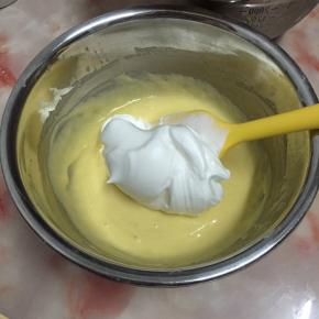 取三分之一蛋白霜加入蛋黄糊中，用翻拌与切拌将面糊拌匀。