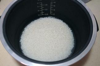 2.	适量的大米入电饭煲内胆中，根据自家食用量来定，清洗两遍后加凉水，水量比你家平时焖饭的水量少三分之一；