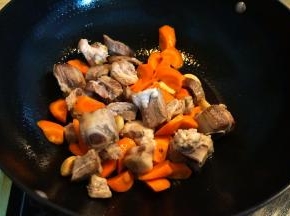 4.	炒锅中倒一点点油，大蒜煸炒出香味后将排骨和胡萝卜入锅中翻炒；