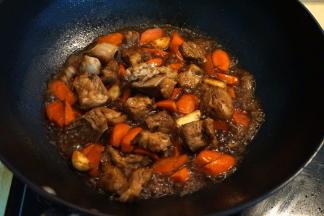 6.	再倒入热水，水量不要太多，是刚好能把排骨烧熟的量就成，太多水会让米粒粘成坨, 两分钟就可以，就是让排骨能上色；