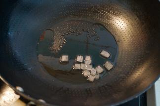 2.	炒锅中倒一点点油，放入一小把冰糖；