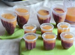 7.将哈密瓜汁缓缓倒入冰棍模具中，如果想要分层明显，可以准备一只小卵子，将果汁倒在勺背上，这样就能比较均匀地布在葡萄汁表面而不会混合了；