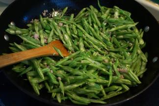 5.将豆角丝入锅中翻炒变色；