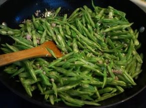 5.将豆角丝入锅中翻炒变色；