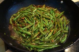 6.倒入适量酱油、热水，混合均匀后，盖盖子，中小火焖熟；起锅前撒少许盐、倒少许生抽，翻拌均匀，出锅；