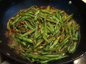 6.倒入适量酱油、热水，混合均匀后，盖盖子，中小火焖熟；起锅前撒少许盐、倒少许生抽，翻拌均匀，出锅；