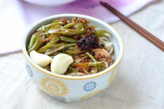 8.面条入碗中，浇上豆角丝，还可以淋点醋、辣椒油，一定要啃几瓣大蒜才够味儿噢！