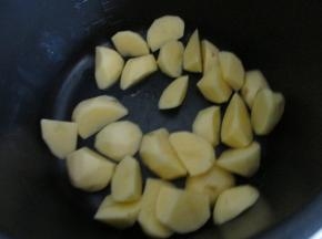 土豆去皮切块，放到电压力锅底部。