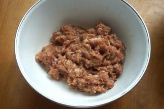 2.猪肉馅中加三小勺植物油、适量盐、生抽、葱花、姜末、凉水，顺着一个方向搅拌成糊；我今天用的肉馅是上顿做丸子剩下的，放冰箱里冷藏保存了一晚；