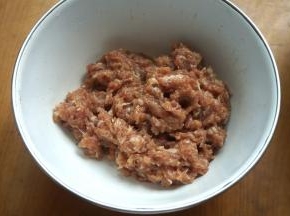 2.猪肉馅中加三小勺植物油、适量盐、生抽、葱花、姜末、凉水，顺着一个方向搅拌成糊；我今天用的肉馅是上顿做丸子剩下的，放冰箱里冷藏保存了一晚；