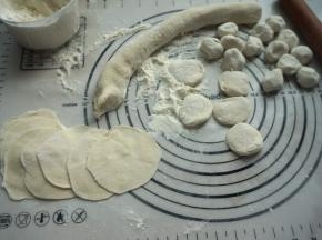 5.面团取出放在揉面垫上，搓成细长条，切成大小均匀的剂子，擀成边缘略薄中间稍厚的圆皮；