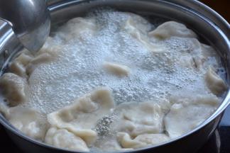 9.水开后，将饺子入锅中，用勺子沿着锅边推动，防止饺子沾连或者沉底儿；待分别煮开两次时，点少许凉水降温，直到饺子的肚子鼓鼓的，全部浮到水面上时，笊篱捞出