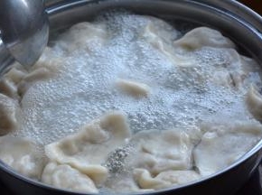 9.水开后，将饺子入锅中，用勺子沿着锅边推动，防止饺子沾连或者沉底儿；待分别煮开两次时，点少许凉水降温，直到饺子的肚子鼓鼓的，全部浮到水面上时，笊篱捞出