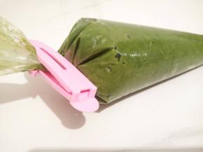 用手揉裱花袋里面的面糊，让空气挤出来，利于裱花把封口拧紧，用封口夹子夹好（裱花的时候面糊不会往上跑）