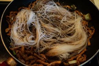 7.将泡软剪短的粉丝入锅中，迅速翻炒，使粉丝能吸入汤汁；