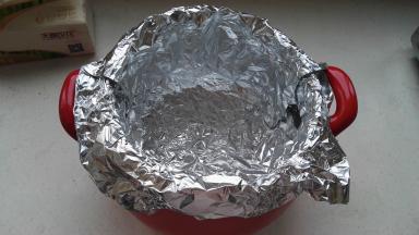 另一张锡纸也放入砂锅，十字交叠成直筒状，一圈贴牢砂锅内壁，顶部包住砂锅边沿。