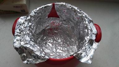 裁三张比锅体大的锡纸，取一张锡纸放入锅内，一圈用手按压贴牢砂锅内壁，顶部包住砂锅边沿伸出锅外。