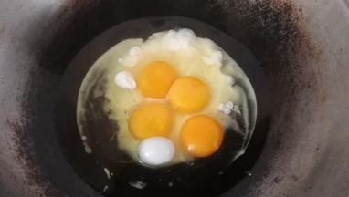 2.炒锅中倒适量油，比炒菜油略多些，鸡蛋直接磕入锅中；