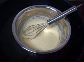 在烤面包的过程中，制作奶酪馅。先把牛奶加入到奶油奶酪中，然后隔水加热搅拌至顺滑状态。