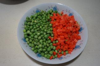 1.豌豆去豆荚，如果豆荚很嫩，可以撕掉老皮和筋，留着嫩嫩的豆荚炒着吃，胡萝卜切成和豌豆大小的丁；
