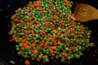 7.将豌豆胡萝卜丁倒入锅中，撒少许盐，再倒适量的热水煮开；