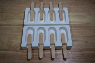 将配置的冰棒木棍插入模具。