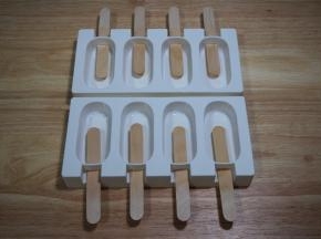 将配置的冰棒木棍插入模具。