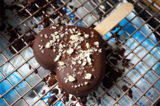 将30度左右的巧克力液快速淋面，同时撒上果仁碎装饰。