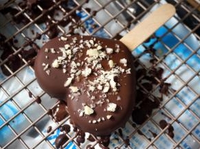 将30度左右的巧克力液快速淋面，同时撒上果仁碎装饰。