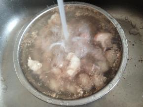 将猪蹄放进另一个盆里，用流动的水冲洗一下。