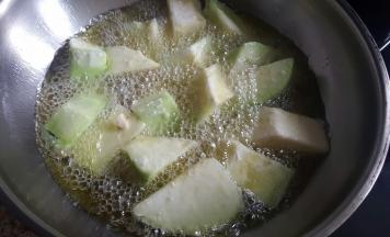 10.炒锅中加适量的花生油，炸茄子块。