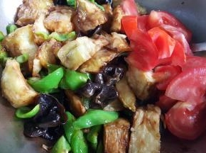 15.加入茄子块和番茄块一同炒，这时可以加适量的新盐和酱油进行调味。